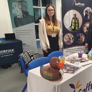 Apprentice Standing Behind A Marketing Table 