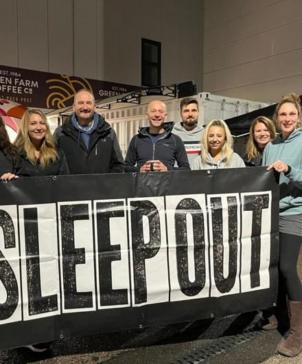 Saffron Staff Holding And Standing Behind A Sleep Out Sign 