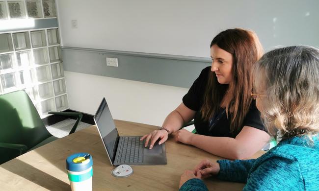 Staff And Tenant Group Member Sitting At A Desk