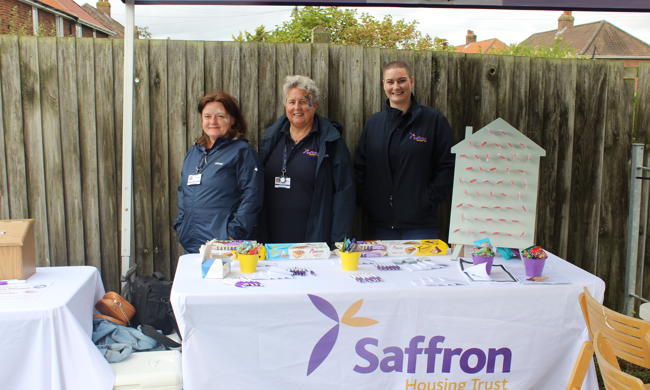 Saffron Staff Members Stood Behind Merchandise Table
