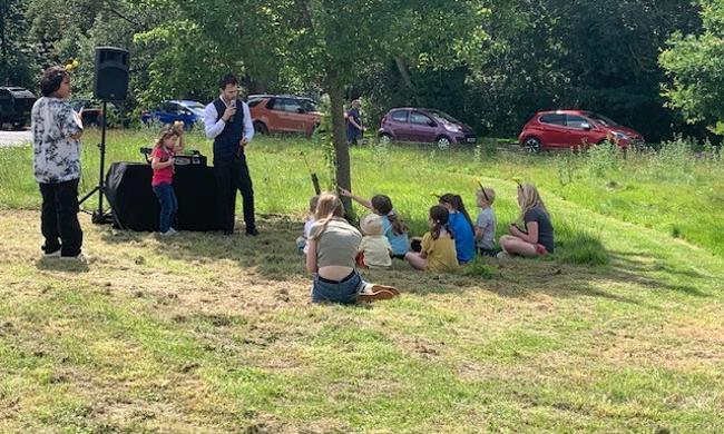 Children Watching Entertainer On Green 