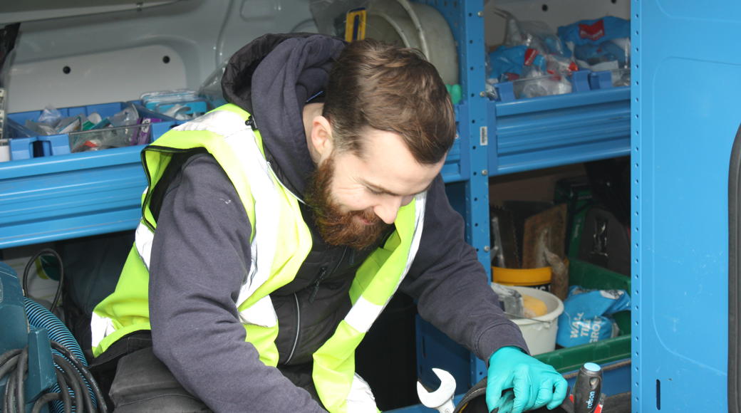 Saffron Craftworker In High Vis Jacket Looking At Tools Inside Van